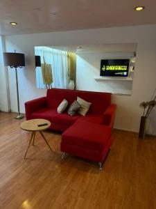 a living room with a red couch and a table at Hotel Plaza in Concepción del Uruguay