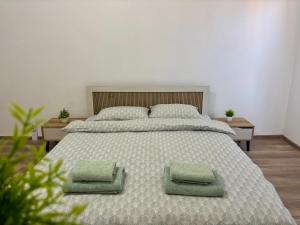 a bedroom with a large bed with two green pillows at KA Home in Petrich