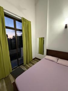 a bedroom with a bed and a large window at Eldorado Apartments F2P3 Wattala in Alwis Town