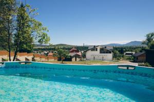a large swimming pool with a house in the background at Апартаменти Helleborus in Staryy Mizunʼ