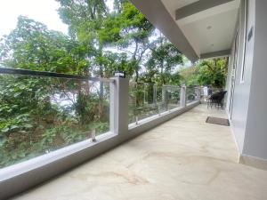 an empty balcony with a view of trees at Stayat77 in Karsiyang