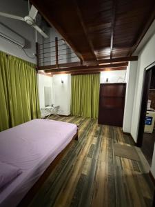 a bedroom with a bed and green curtains at Eldorado Apartments F2P3 Wattala in Alwis Town