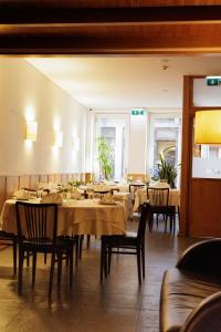 a dining room with tables and chairs in a restaurant at Pensao O Laranjeira in Viana do Castelo