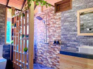 a bathroom with a shower in a brick wall at Cinnamon River Cabana in Ella +214 photos