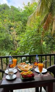 a wooden table with food and orange juice on it at Simoya Nature Park in Dambulla