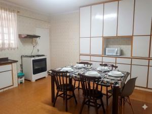 ein Esszimmer mit Tisch und Stühlen in einer Küche in der Unterkunft Apartamento Gonzaga Santos in Santos