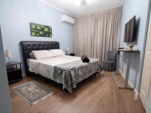 ein Schlafzimmer mit einem Bett und einem Fernseher in der Unterkunft Apartamento Gonzaga Santos in Santos