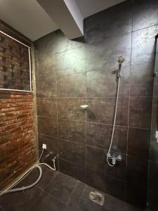 a bathroom with a shower with a brick wall at Eldorado Apartments F2P3 Wattala in Alwis Town