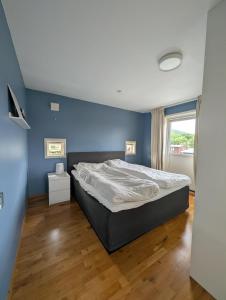 a bedroom with a bed and a blue wall at Kongleveien 11C in Sandnes