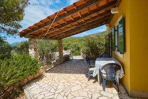 a patio with a table and chairs under a pergola at Lošinj house Robinzon Studenčić Island Lošinj in Čunski +22 photos