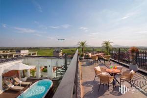 an outdoor patio with tables and chairs and an airplane at Noi Bai Horizon Hotel & Spa in Noi Bai