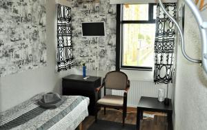 a bedroom with a bed and a chair and a window at Hotel Hanhi in Lapinjärvi