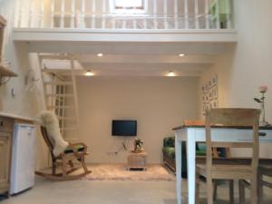 a living room with a loft bed and a tv at Het Huisje Breda in Breda