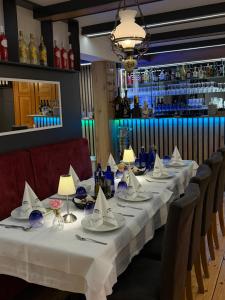 a long table with white tablecloths and napkins at Hotel La-Pergola in Kolkwitz