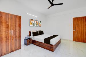 a bedroom with a bed and a ceiling fan at Super Hotel O Destiny Inn in Pune