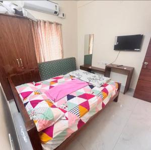 a bedroom with a bed with a colorful quilt on it at SN Grand lodge AC in Badvel