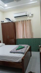 a bedroom with a bed with a green pillow on it at SN Grand lodge AC in Badvel