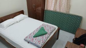 a bed with a green napkin sitting on it at SN Grand lodge AC in Badvel
