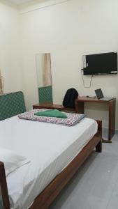 a bedroom with a bed and a desk and a television at SN Grand lodge AC in Badvel