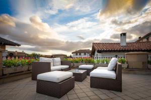 a patio with wicker chairs and tables on a roof at Hotel Casa Azcona in Zizur Mayor