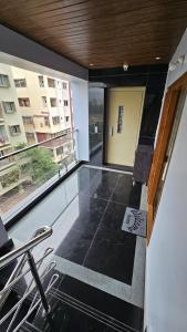 a room with a balcony with chairs and a window at Hill View Haven in Rushikonda