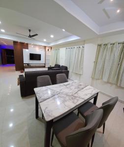 a dining room and living room with a table and chairs at Hill View Haven in Rushikonda