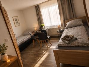 a bedroom with a bed and a desk and a table at Hotel & Restaurant Hasa in Gernrode - Harz