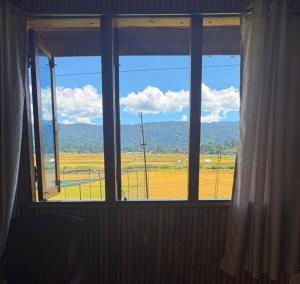 a window in a room with a view of a field at Marmo in Ziro
