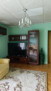 a living room with a large television and a chandelier at Villa Tira in Jajce