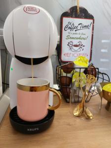 a coffee maker is pouring coffee into a cup at Secret Garden House in Surduk