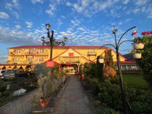 a large yellow building with a street light in front of it at Motel Biamin in Tăşnad