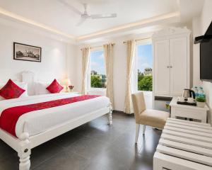 a white bedroom with a bed and a chair at Hotel Pinky Villa-Heritage Boutique Suites Near New Delhi Train station & Connaught place in New Delhi +81 photos
