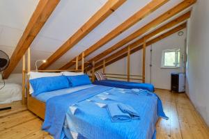 a bedroom with a blue bed in a attic at Lošinj house Robinzon Studenčić Island Lošinj in Čunski