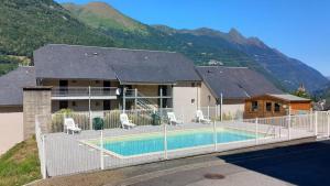 a house with a swimming pool in front of a mountain at T1 cabine de Letious in Luz-Saint-Sauveur