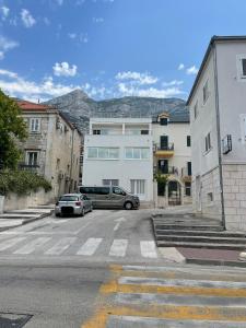 a parking lot with cars parked in front of buildings at Apartmani Paula in Makarska
