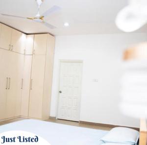 ein Zimmer mit einem Bett und einem Deckenventilator in der Unterkunft Omane Homes in Cape Coast