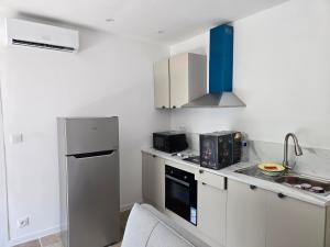 a kitchen with a refrigerator and a sink at Yamna in Perpignan