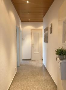a hallway with a white door and a potted plant at City Comfort Hannover in Hannover