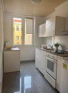 a kitchen with white appliances and a window at City Comfort Hannover in Hannover