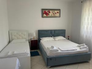 a bedroom with two beds and a picture on the wall at Ersi Apartment in Durrës