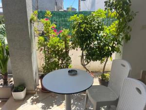 a white table and chairs on a balcony with plants at Ersi Apartment in Durrës +5 photos