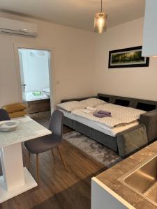 a bedroom with a bed and a kitchen with a sink at Penzion TONNY in Podivín