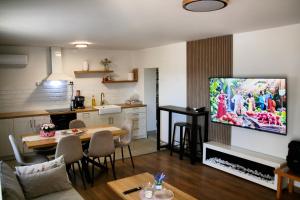 a living room with a tv and a kitchen at Vila Daško in Lukavac
