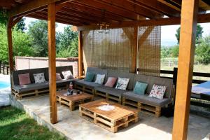 a patio with two couches and a table at Vila Daško in Lukavac