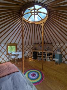 a yurt with a table and chairs and a window at Martinická jurta in Martinice u Dolních Kralovic