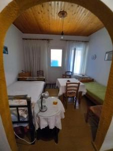a bedroom with a bed and a table and chairs at ΑΝΝΑ'S Πύργος - ΣΑΜΟΣ in Pýrgos