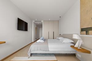 a bedroom with a bed and a tv on a wall at La maison de simon in Pietrosella +27 photos