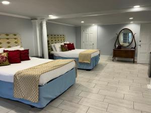 a hotel room with two beds and a mirror at The Inn at Cedar Grove in Vicksburg