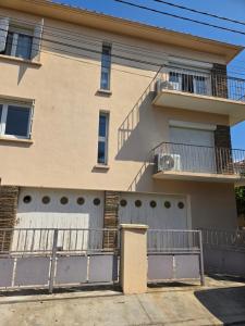 a house with two garage doors and a balcony at Yamna in Perpignan