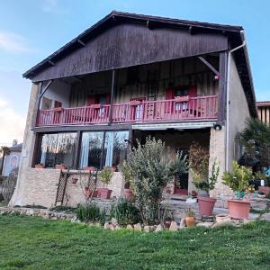 a house with a balcony on the side of it at Le Logis du Rocher in Saint-Marcet